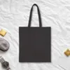 Plain back of the black canvas tote with the Baggage Claim design, printed on the front only
