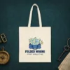 folded-wrong-tote-natural-front Folded Wrong design in navy ink on a natural canvas tote, laid flat on the leather lid of a travel trunk