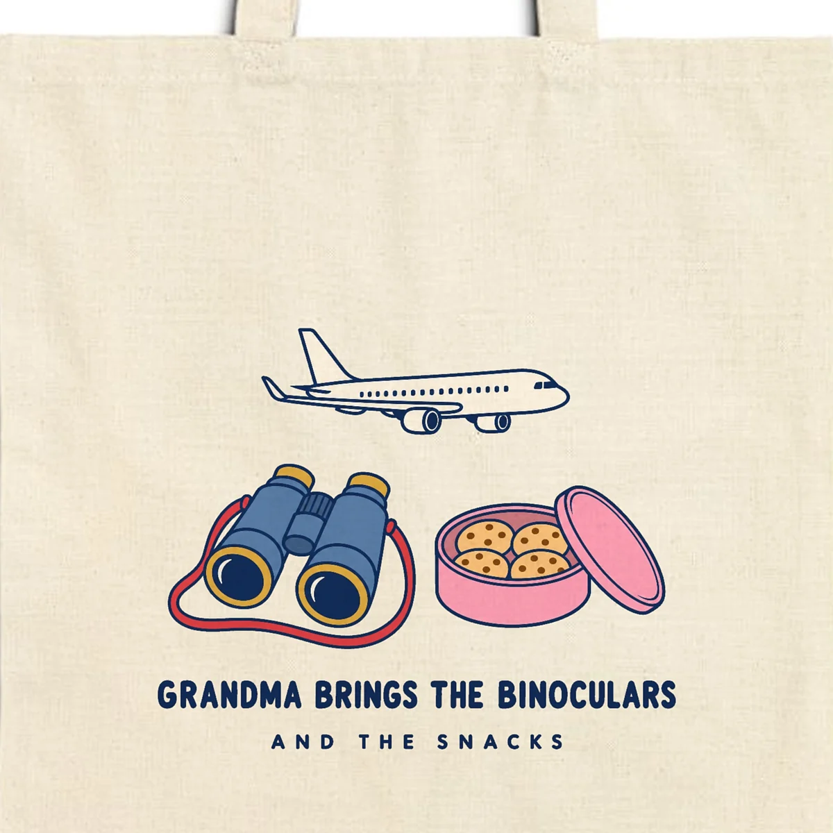 Close-up of the Grandma Brings the Binoculars design printed in navy ink on a natural canvas tote, with the top seam and handles