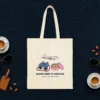 Grandma Brings the Binoculars design in navy ink on a natural canvas tote, laid flat on an airport lounge carpet