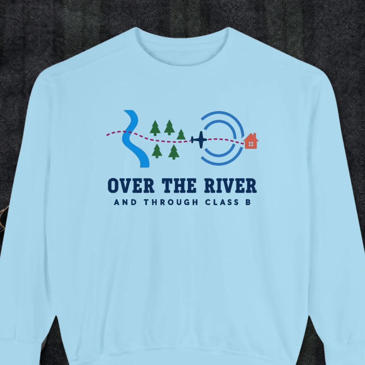 Over the River design on a Chambray Comfort Colors 1566 sweatshirt, laid flat on a winter ground