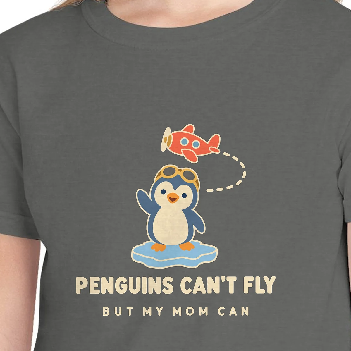 Close-up of the Penguins Can't Fly design on the Pepper kids tee, Comfort Colors 9018 youth tee, with the neckline