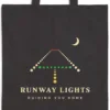 Close-up of the Runway Lights design printed in warm cream ink on a black canvas tote, with the top seam and handles