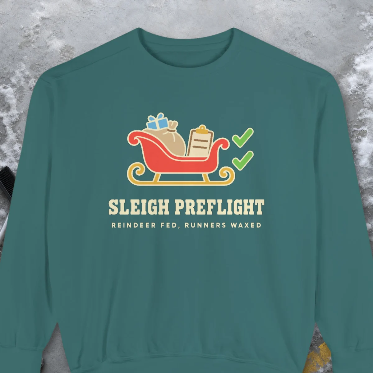 Sleigh Preflight design on a Blue Spruce Comfort Colors 1566 sweatshirt, laid flat on a winter ground