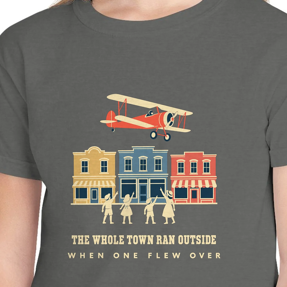Close-up of the The Whole Town Ran Outside design on the Pepper kids tee, Comfort Colors 9018 youth tee, with the neckline