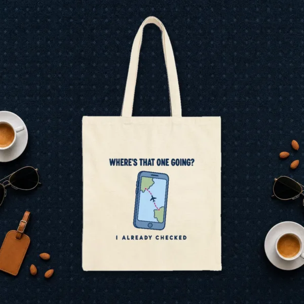 wheres-that-one-going-tote-natural-front Where's That One Going design in navy ink on a natural canvas tote, laid flat on an airport lounge carpet